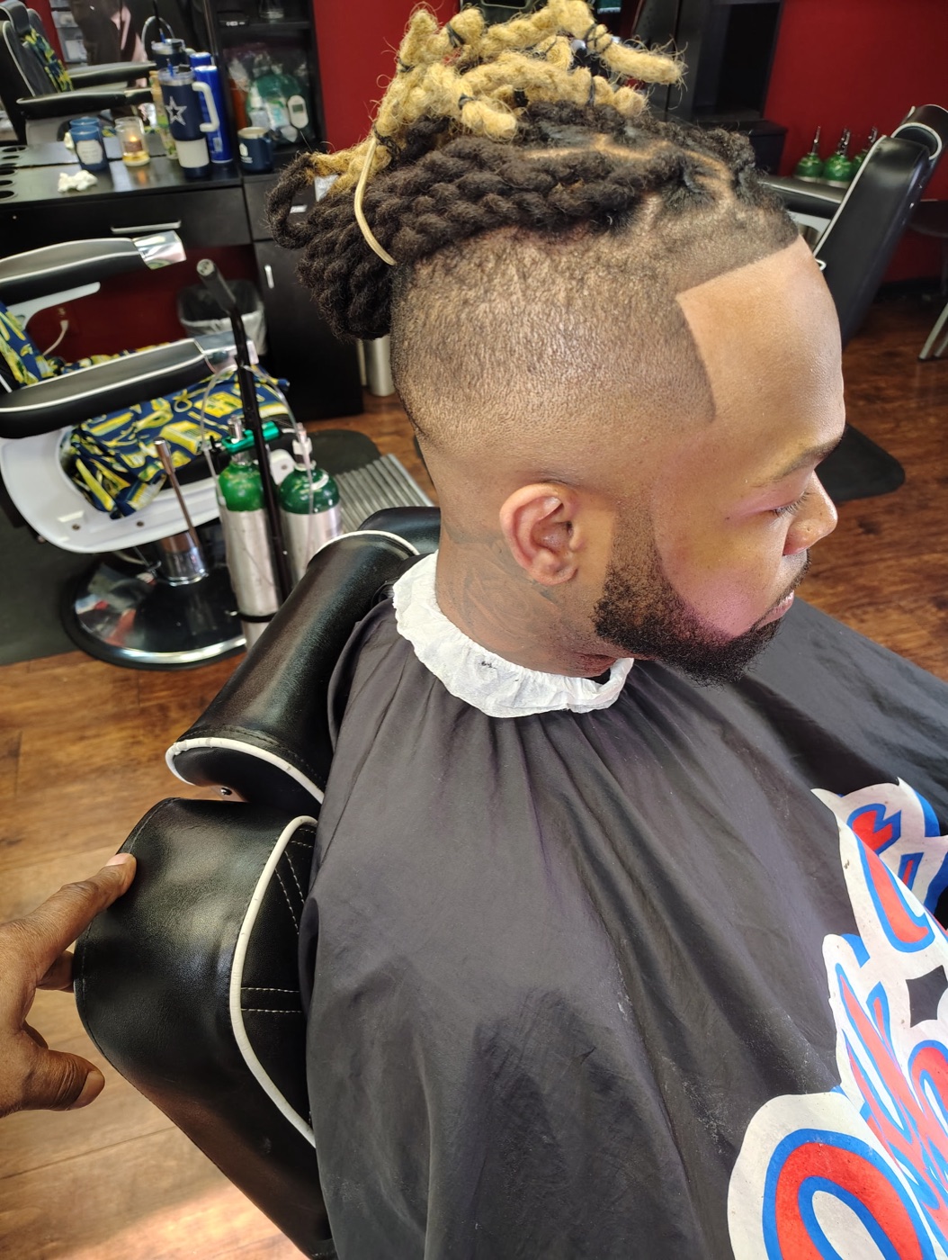 Locs with blonde tips over a high taper fade